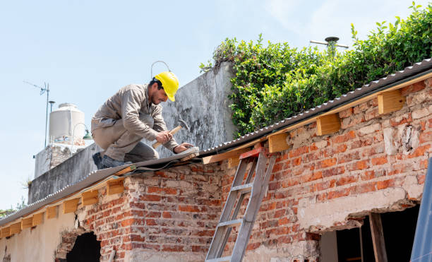 Construction worker using a hammer while installing roof panels on a residential building - Construction industry concepts